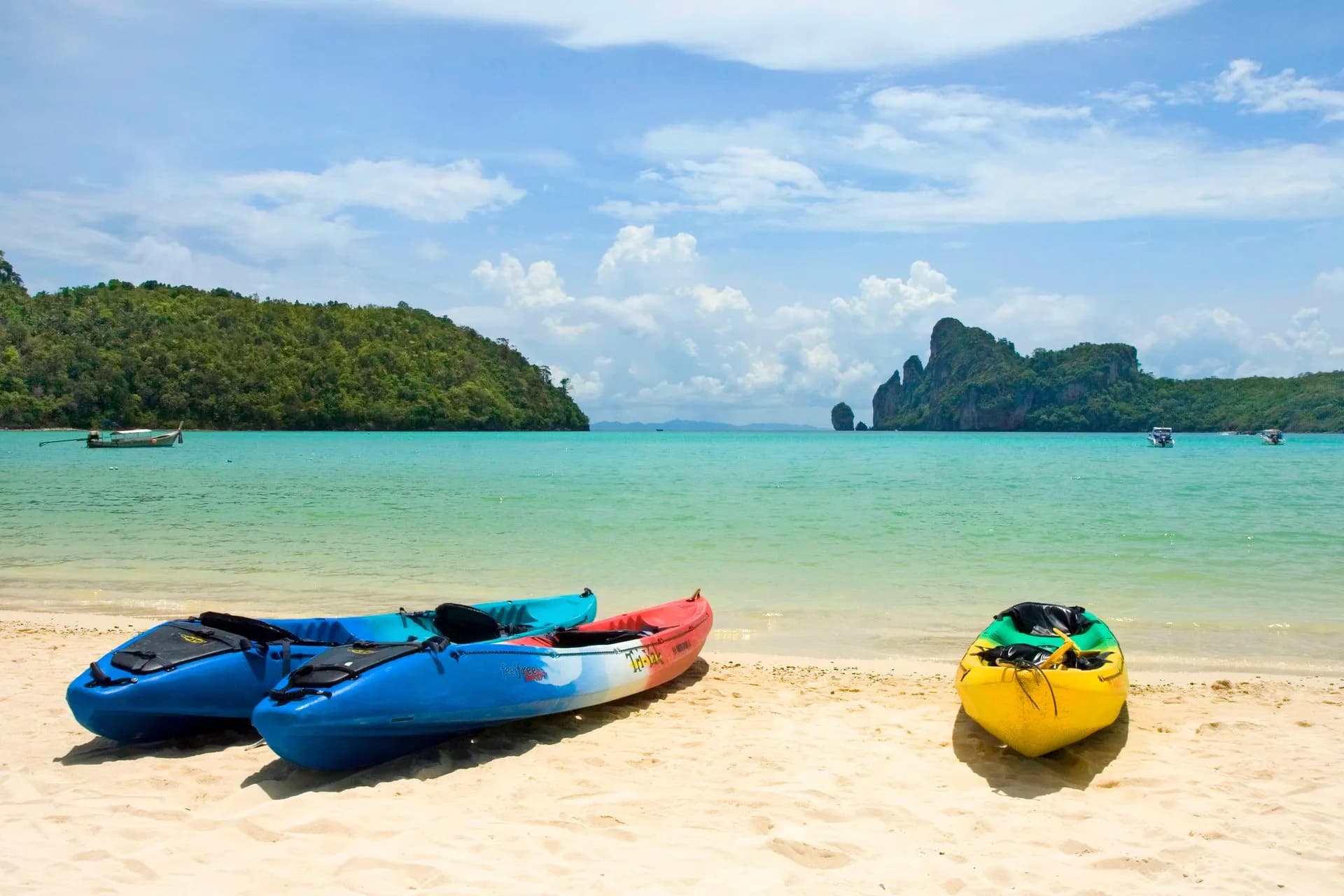 Sea kayak paddling out of a limestone sea cave into a hidden lagoon in Phang Nga Bay near Phuket