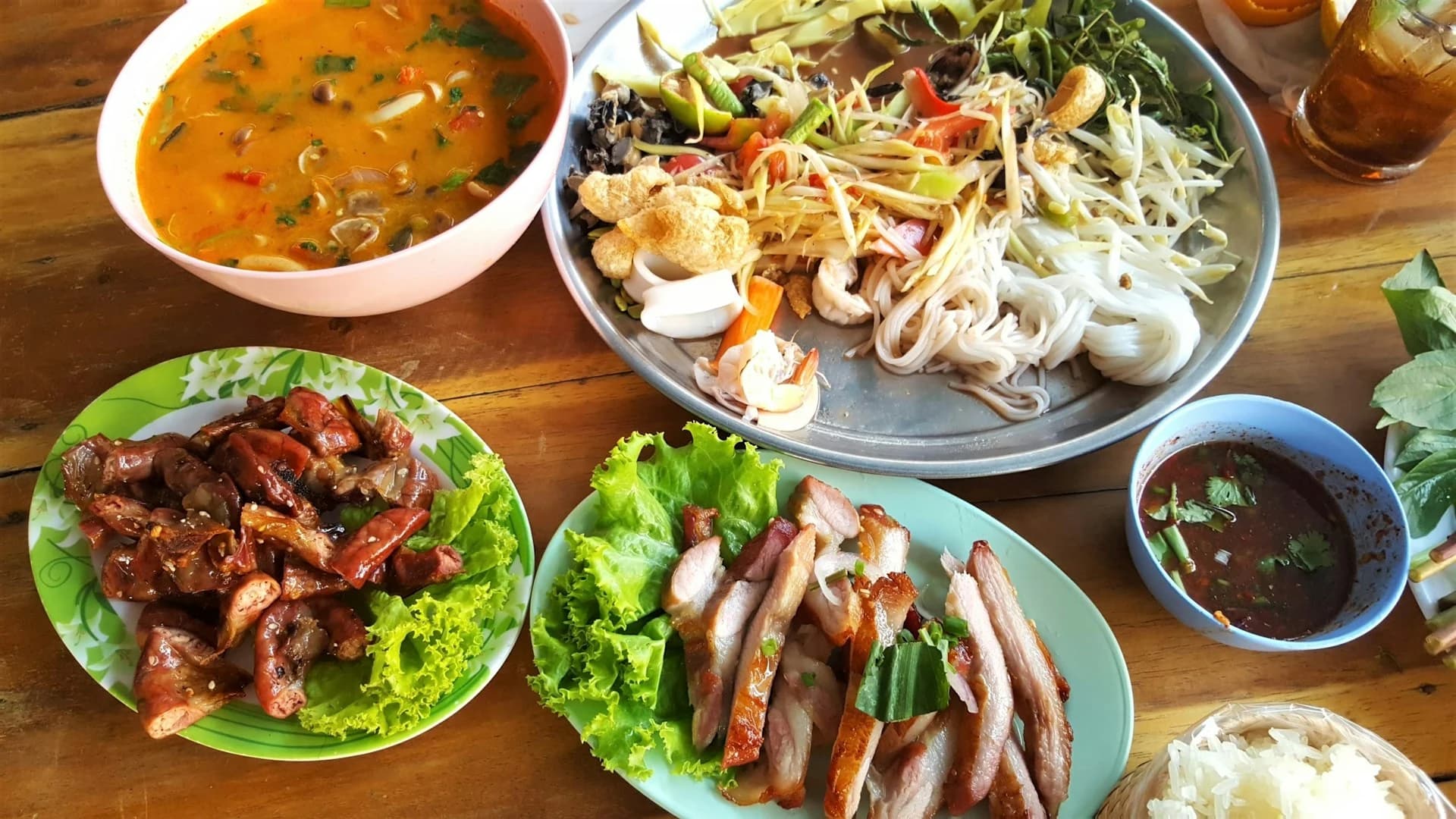 Cooks pounding green curry paste in stone mortars at individual stations in a Phuket kitchen
