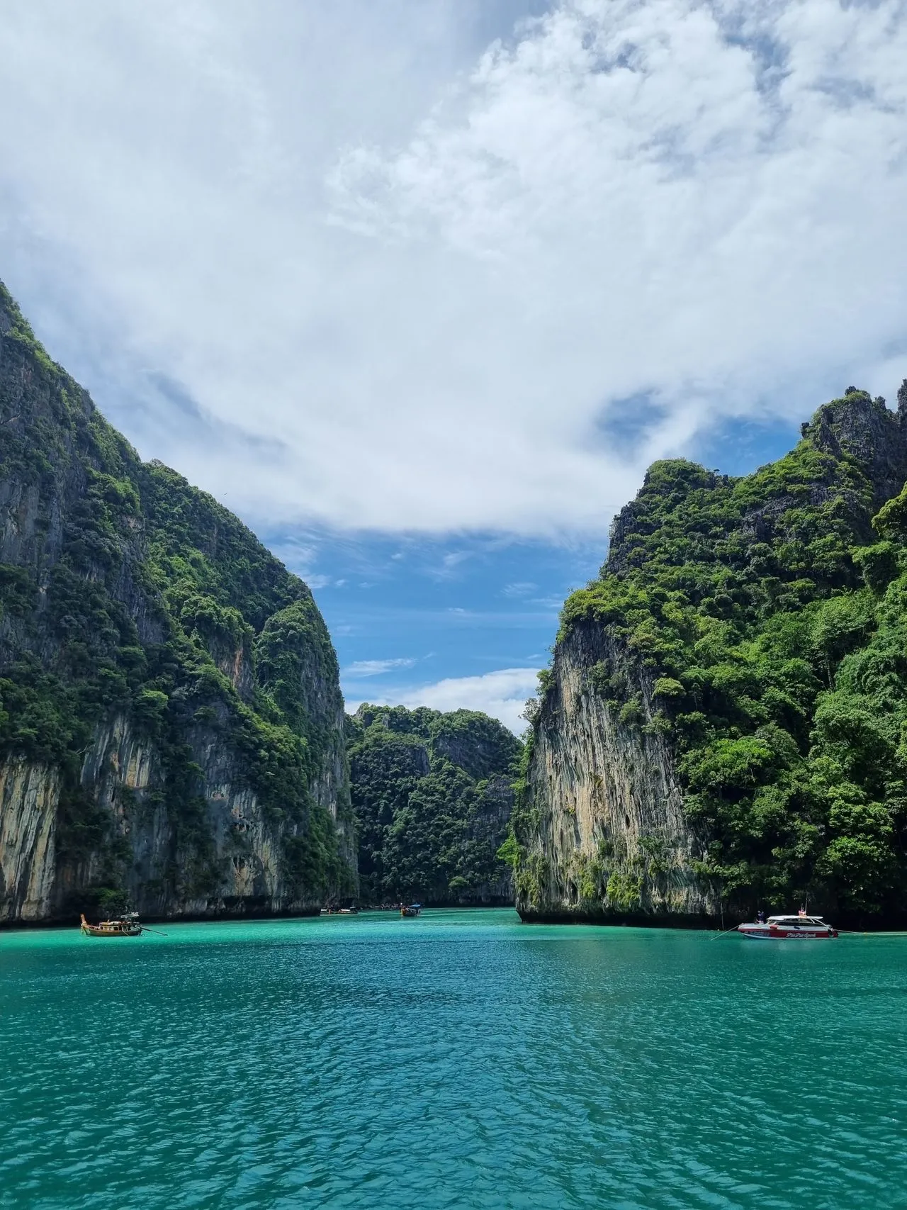 Turquoise water in a bay ringed by steep limestone cliffs in the Phi Phi Islands